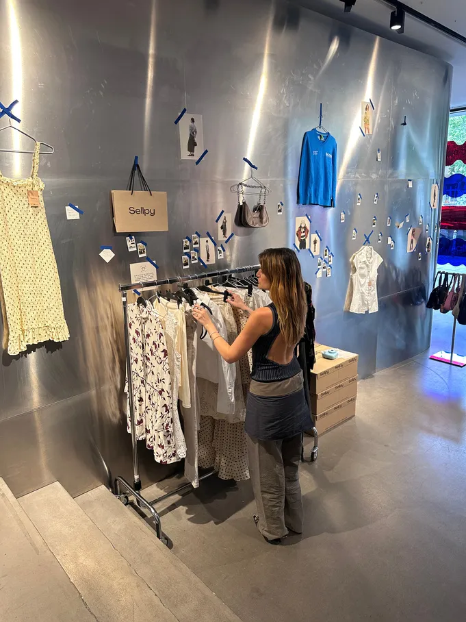 A styling rail and merchandised wall inside a Sellpy store.